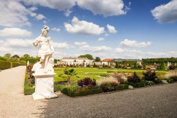 Die Herrenhäuser Gärten Hannover mit dem Schloss Herrenhausen und einer der insgesamt 32 Sandstein-Statuen auf dem Großen Parterre.